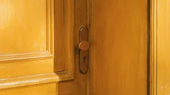 Detail kliky na dřevěných dveřích