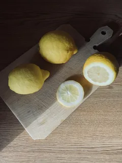 Prkénko s citrony a nožem připravené na krájení